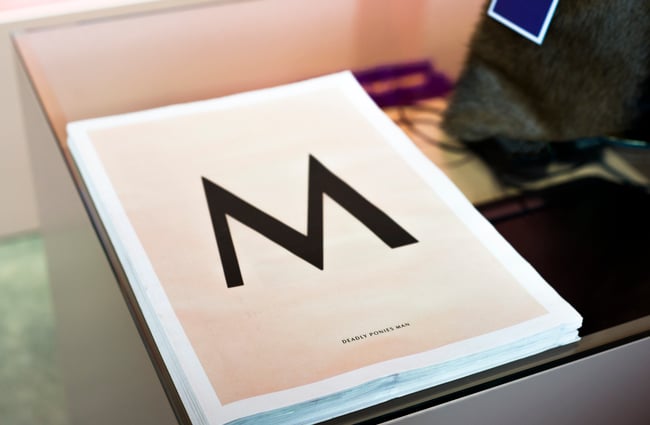 Black M letter on white.