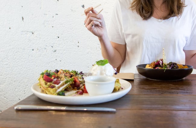 Eating food together on a wooden table.