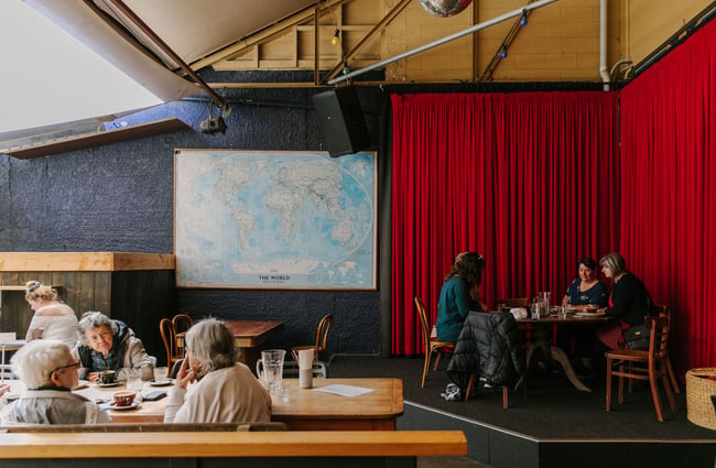 Interior space with people sitting at tables at Deville, Nelson.