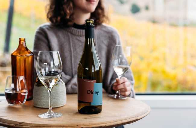 Customer sitting at a table with a glass of wine in hand at Dicey.