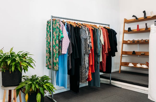 Clothing rack with colourful garments sits on the back wall at Different Avenue.