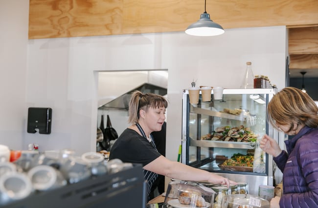 Woman serving a customer at Dispense Espresso in Christchurch.