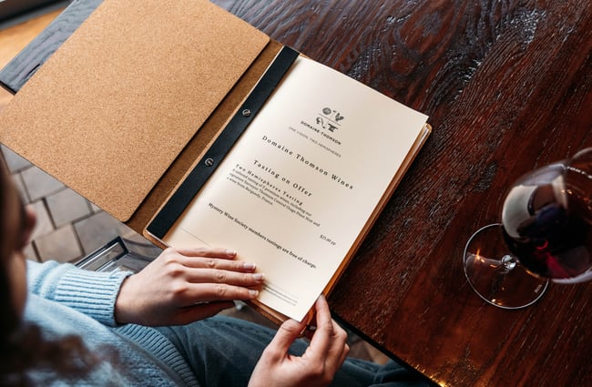 Customer looking at the tasting notes menu at Domaine-Thomson Wines Cellar Door.