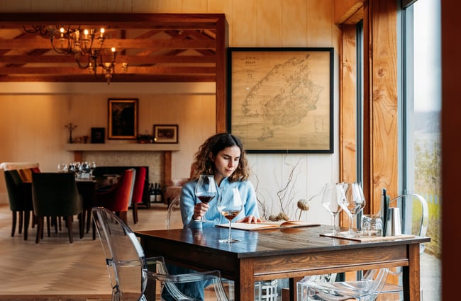Customer sitting at a table drinking a glass of wine at Domaine-Thomson Wines Cellar Door.