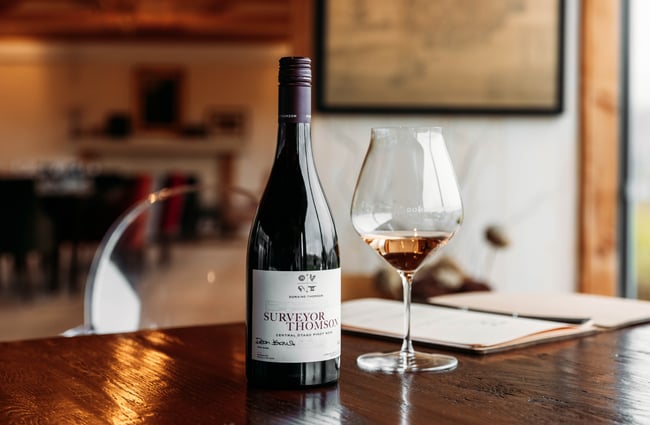 Bottle of wine and a glass on the table at Domaine-Thomson Wines Cellar Door.