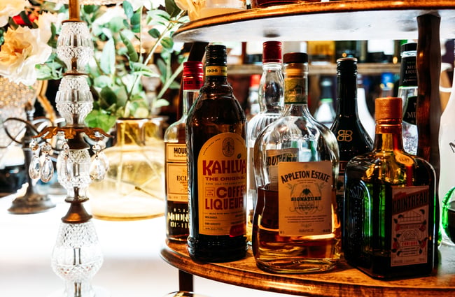 A close up of liquor bottles on a bar top.