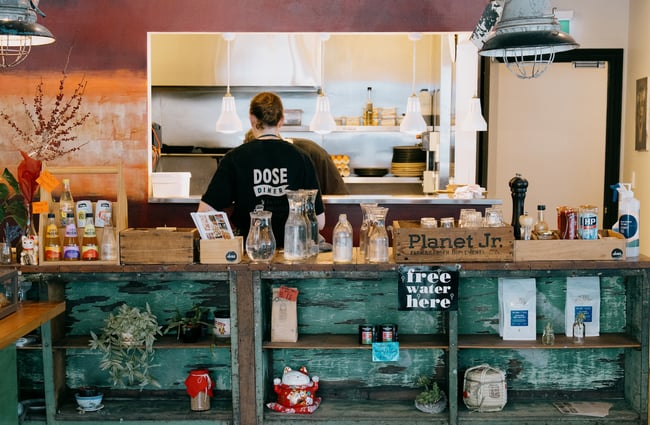 A staff member working behind the counter at a cafe.