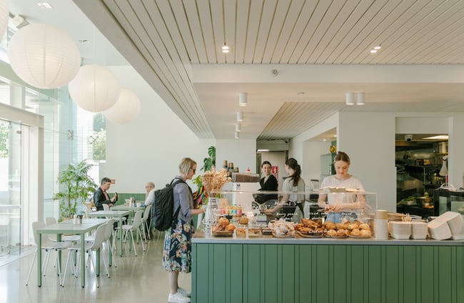 A customer ordering at the white and green counter at Doubles cafe Christchurch.