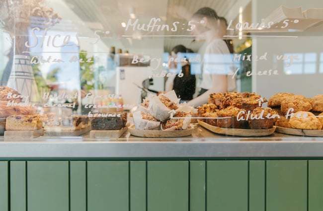 A close up of baked goods in the glass cabinet.