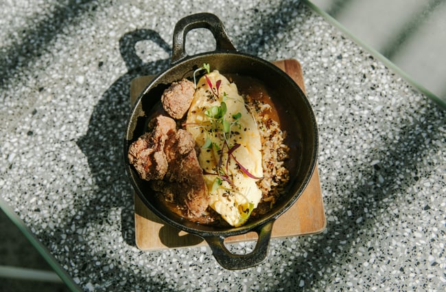 A close up of fried chicken on a hot plate.