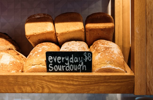 Loaves of sourdough stacked on top of one another on shelf