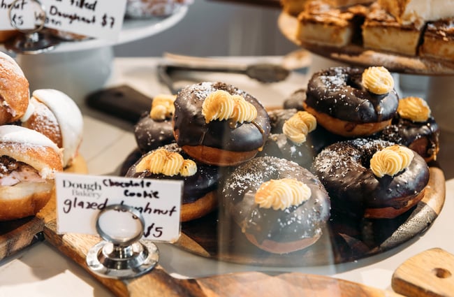 Plate full of chocolate glazed doughnuts in cabinet