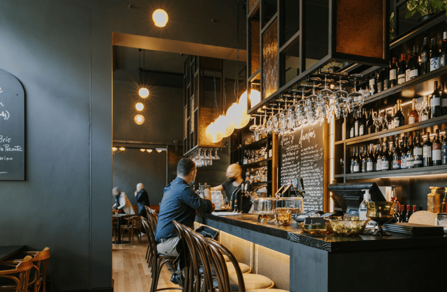 Image of the bar with bar stools with big feature lighting above the bar.