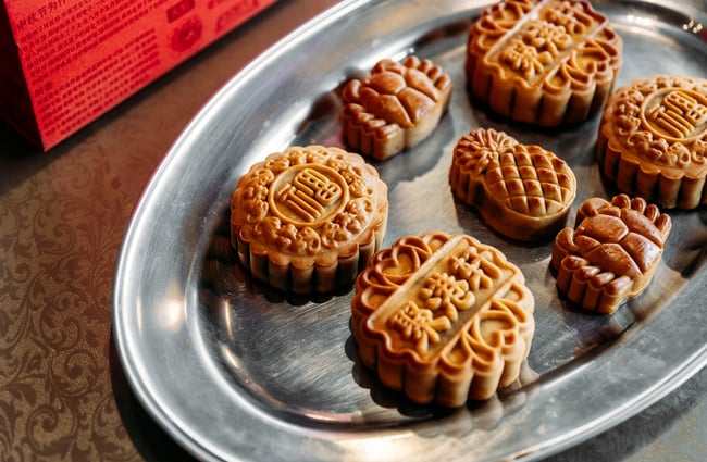 Close up of moon cakes on a silver tray.