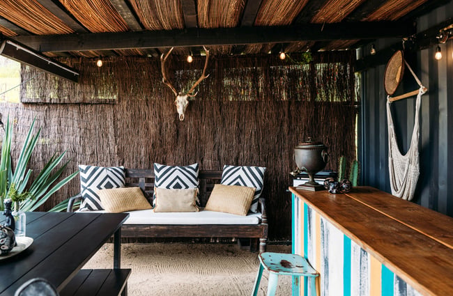 A couch on a deck next to an outdoor kitchen.