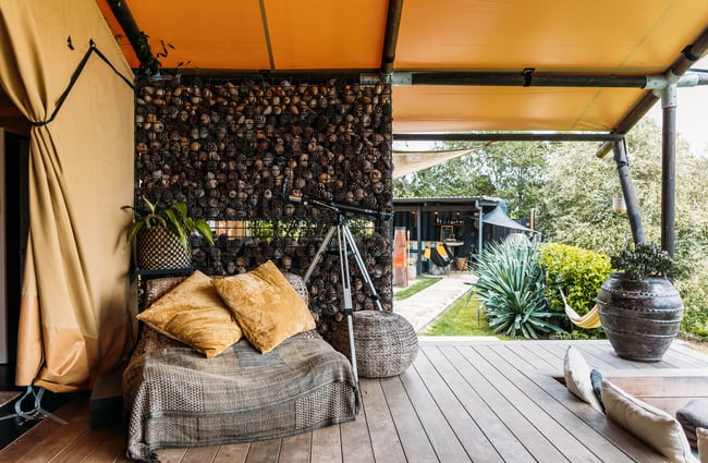 Seats on a deck outside a glamping tent.