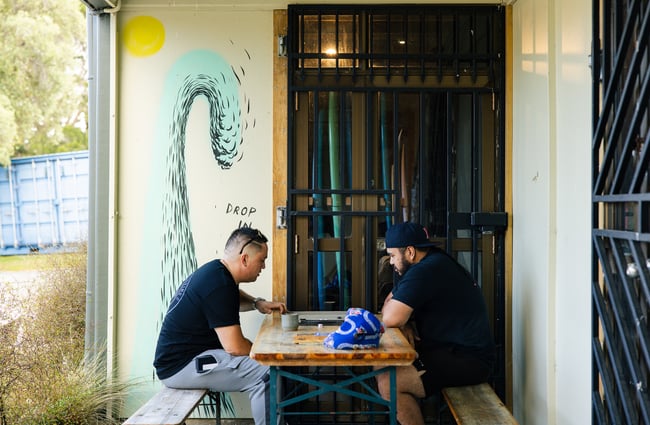 Customers sitting at a table at Drop In Surf & Supply.