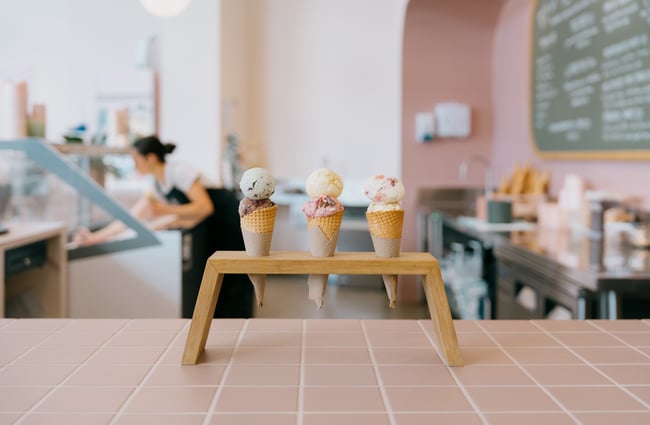 Three ice creams lined up in a row on cones at counter of Duck Island in Christchurch