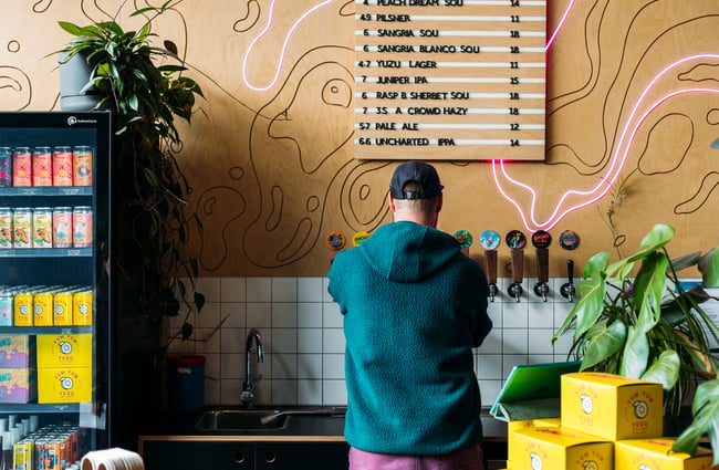 The back of a man pouring beers.