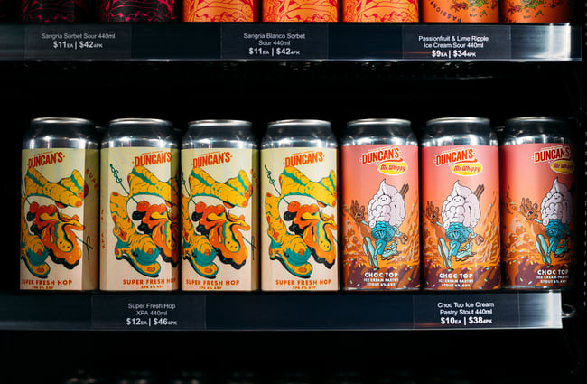 A close up of beer cans in a fridge.