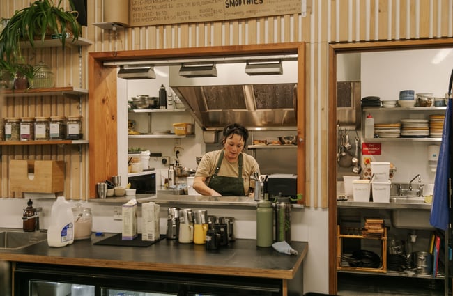 A female chef working away in the kitchen at Dune Cafe.