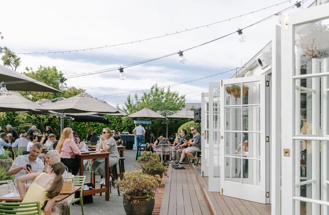 Bi-fold white doors onto deck and courtyard area of Dux Dine in Christchurch.