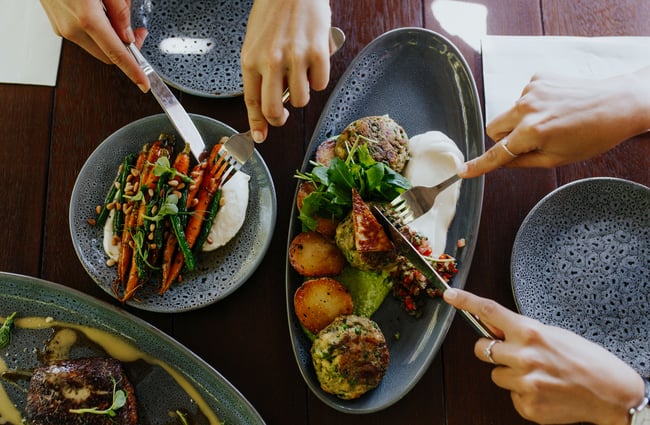 Plates of food being eaten on a table at Dux Dine in Christchurch.