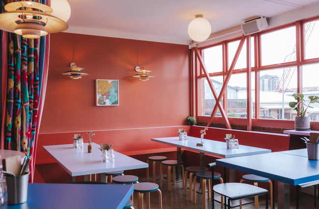 Empty tables and chairs inside the restaurant waiting for customers.