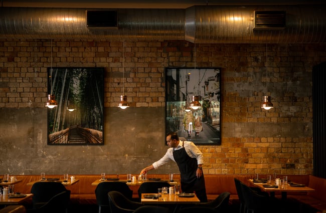 A male staff member setting the table at Ebisu restaurant.
