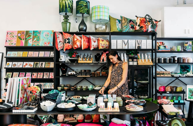 Owner Djurdjica in amongst the shelves and tables of colourful products at Eclectic Design House in Petone