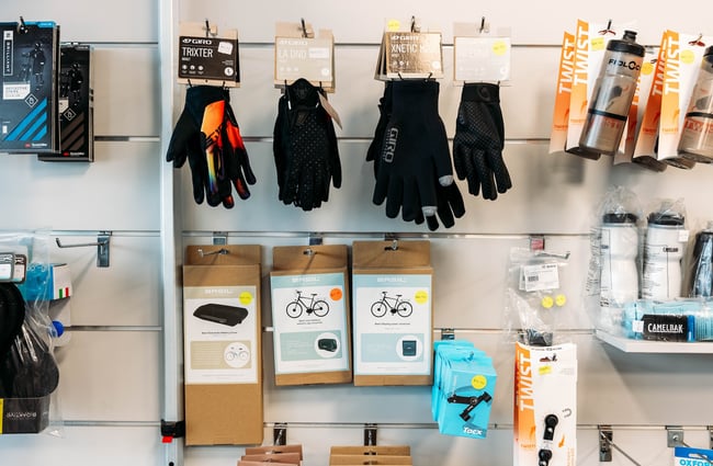 Bike gloves, drink bottles and other accessories hanging on a wall inside Electrify.