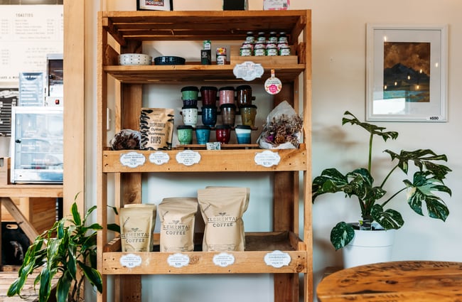 Coffee beans and other products for sale on a shelf at Elemental Eats.