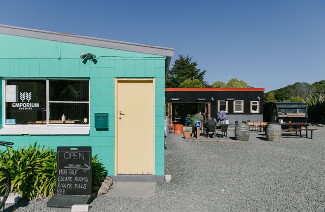 Outdoor seating area with Emporium Brewing sign out front.