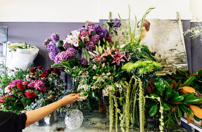 A hand reaching for flowers.
