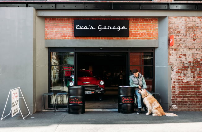 Customer and his dog sitting outside Eva's Garage.