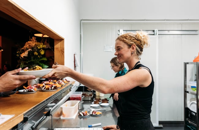 Chef passing plates out at Everybody Eats.