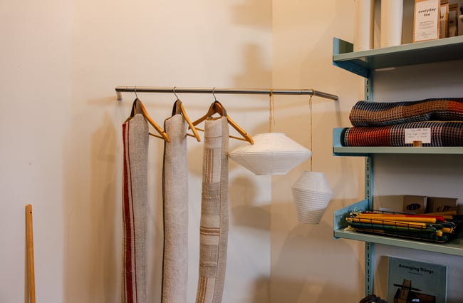 Hanging textiles on rack at Everyday Needs in Ponsonby Auckland