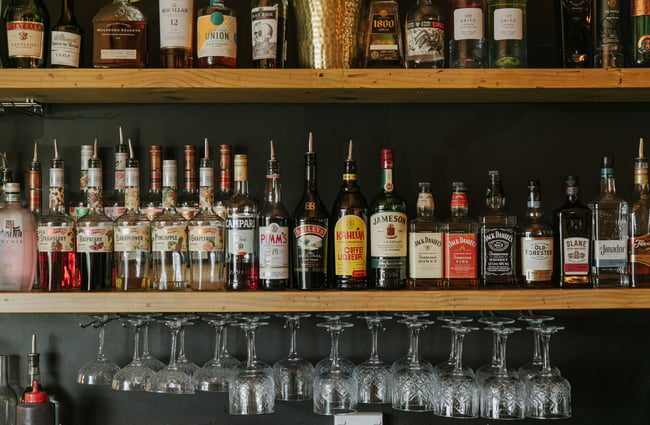 A close up of bottles on spirits on shelves.