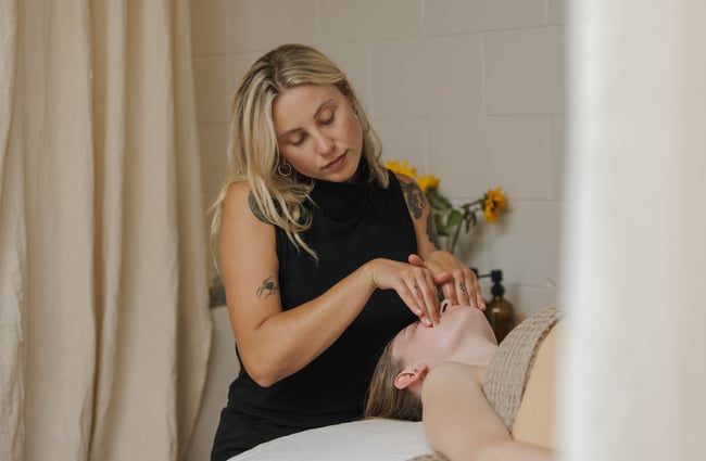 Beauty therapist performing facial massage at Face It in Sumner