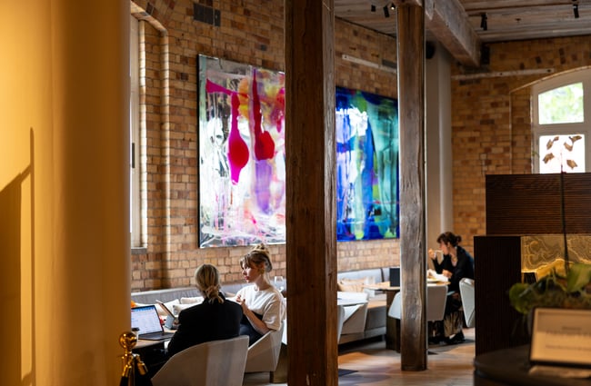 People talking to each other in cafe and bar area with big and colourful contemporary art pieces on wall
