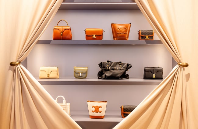 Luxury bags behind curtains at retail shop