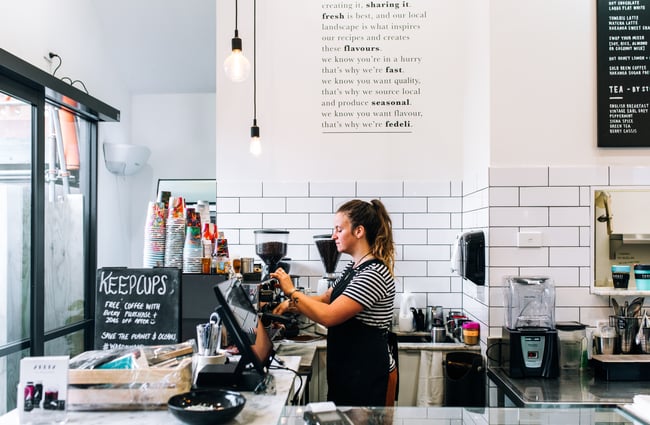 A barista making coffee behind the counter.