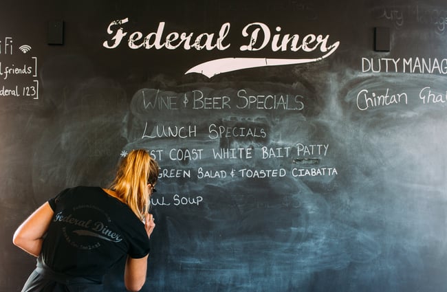A staff member writing on a whiteboard.