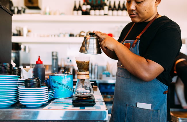 Staff member making a Chemex coffee.
