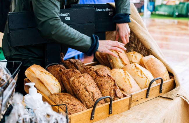 Close up of people buying a loave of bread.