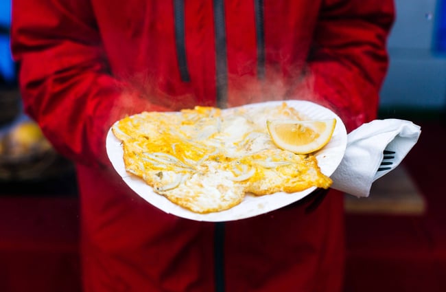 A giant whitebait pattie with a lemon wedge on the side.