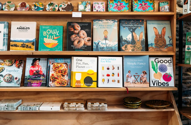 A close up of cookbooks on shelves.