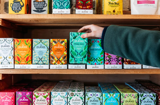 A hand reaching a box of tea.