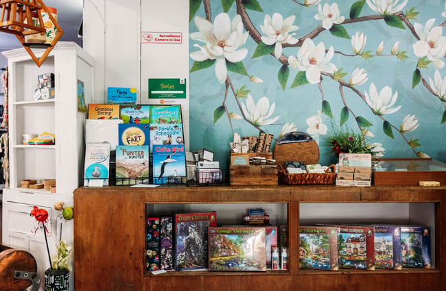 Selection of children's books and puzzles with magnolia wallpaper in the background