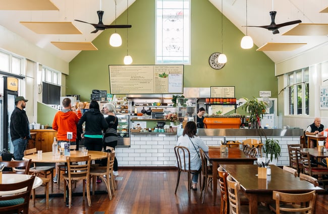 A large cafe space with a green painted wall.